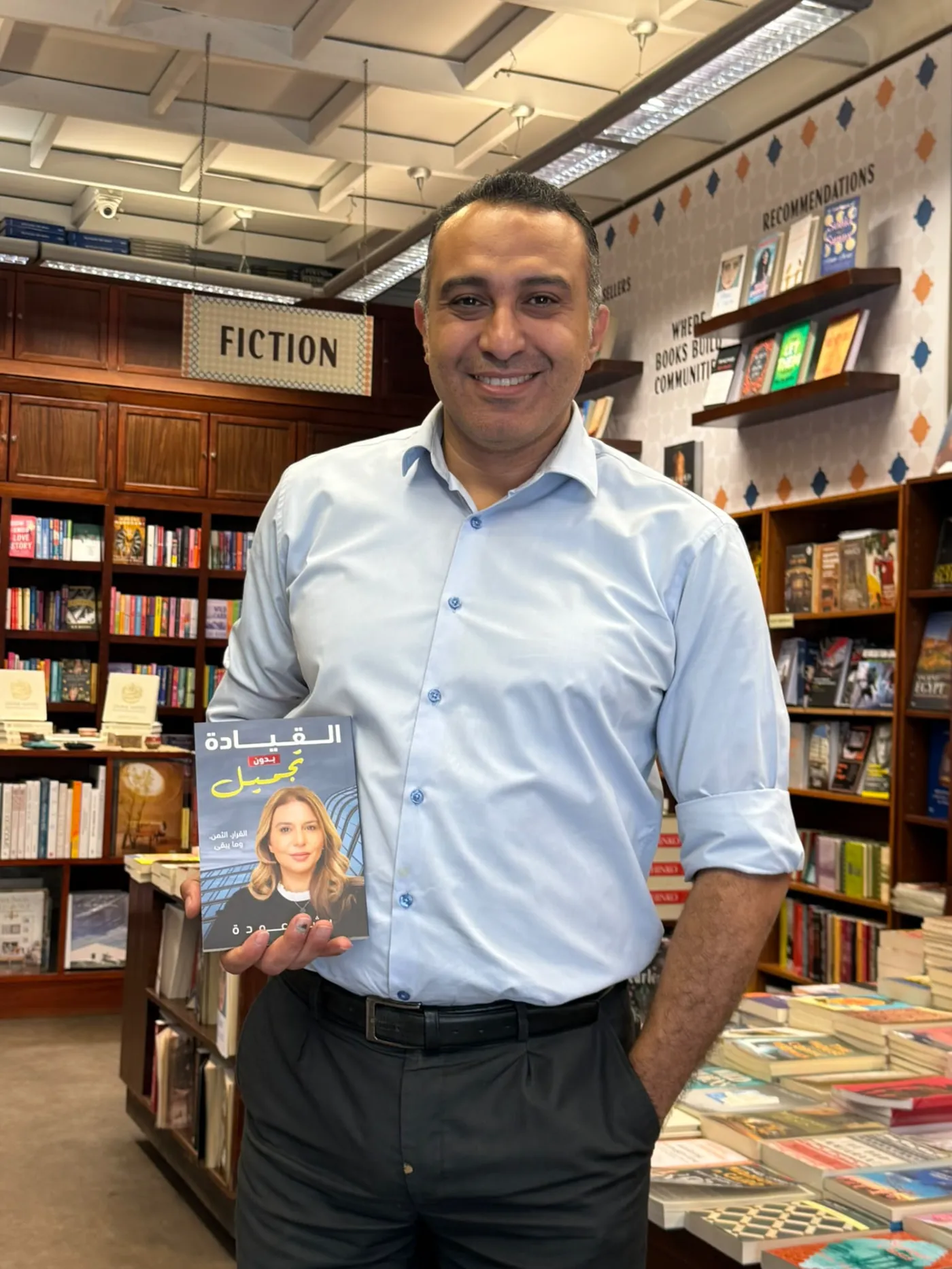 A reader holding the Arabic edition in a bookshop