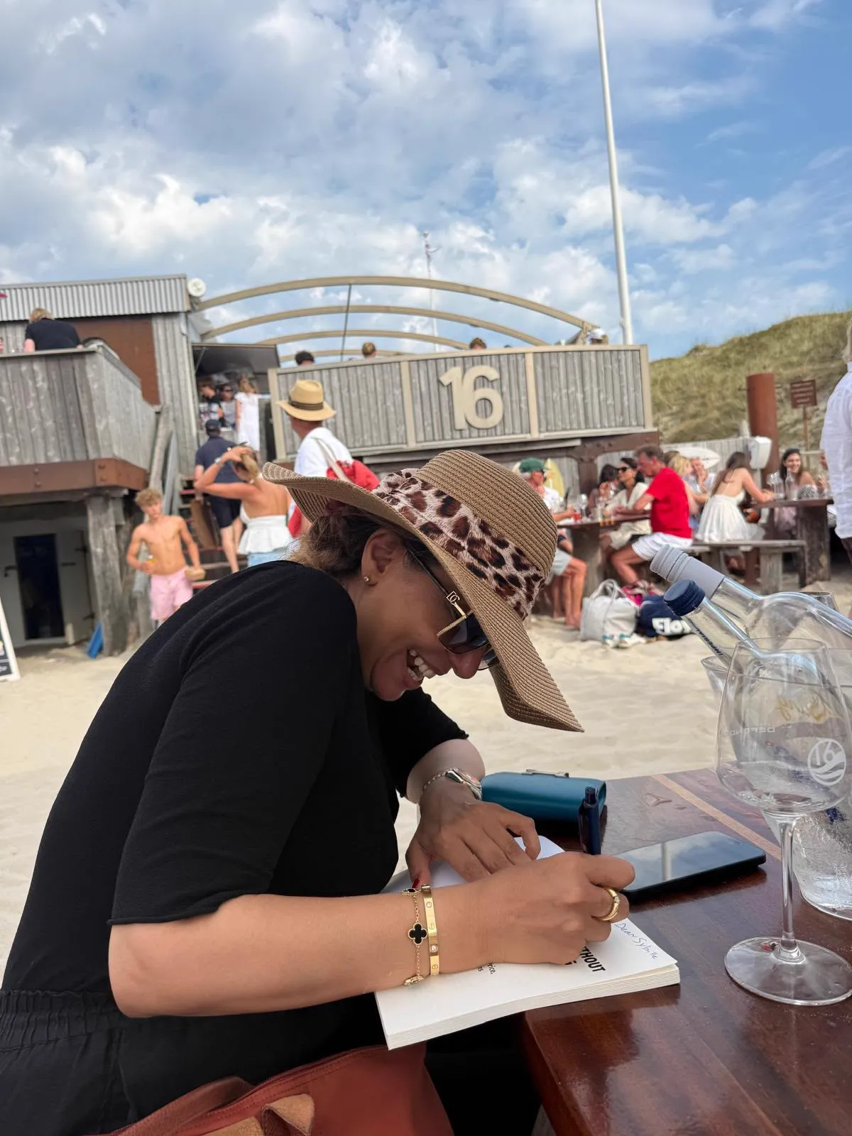 Rasha Oudeh signing a copy of her book by the beach